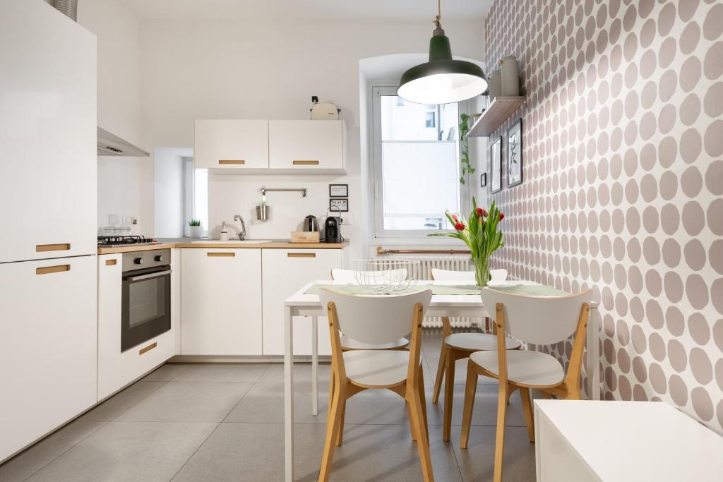 a white kitchen with a table and chairs at Casa Strehler in Trieste