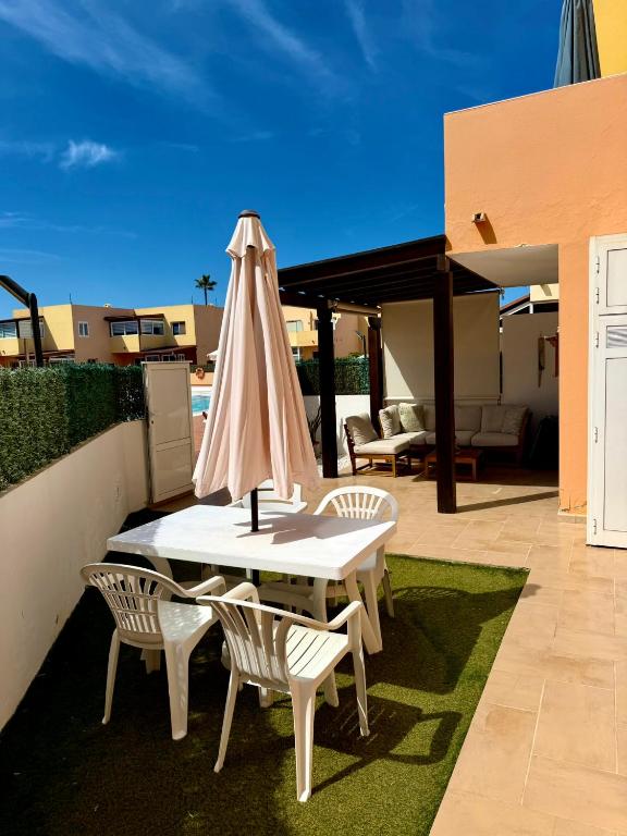 a table and two chairs with an umbrella on a patio at Delfines 61 in Corralejo
