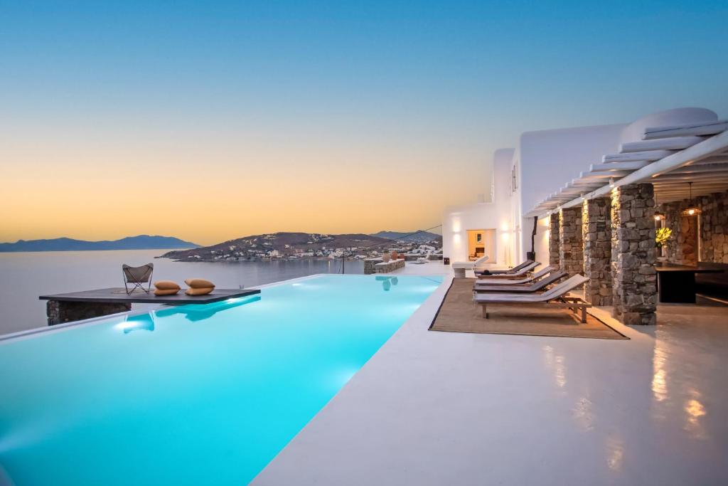 a swimming pool with blue lighting on a building at Maison Haute Mykonos in Ornos