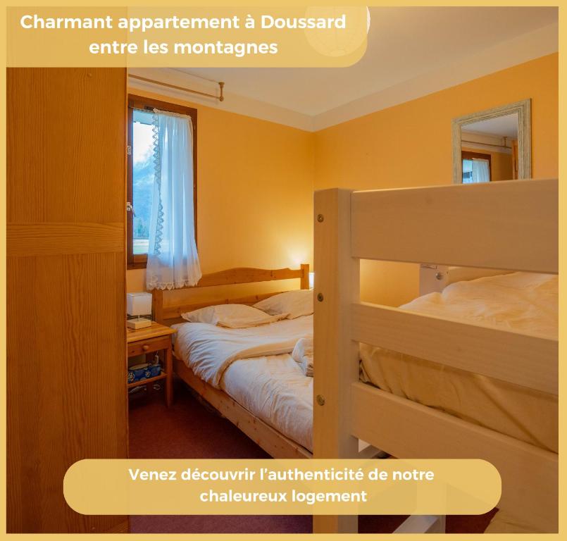 a bedroom with two bunk beds and a window at L'appartement des Cimes I Doussard in Doussard