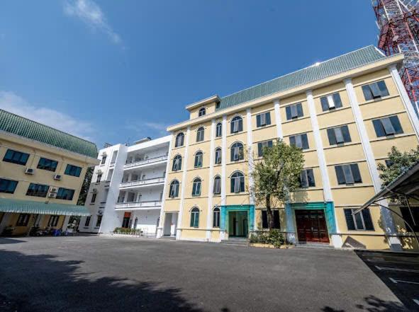 a large white building with a lot of windows at Phố Cổ Legend Hotel in Phúc Lộc