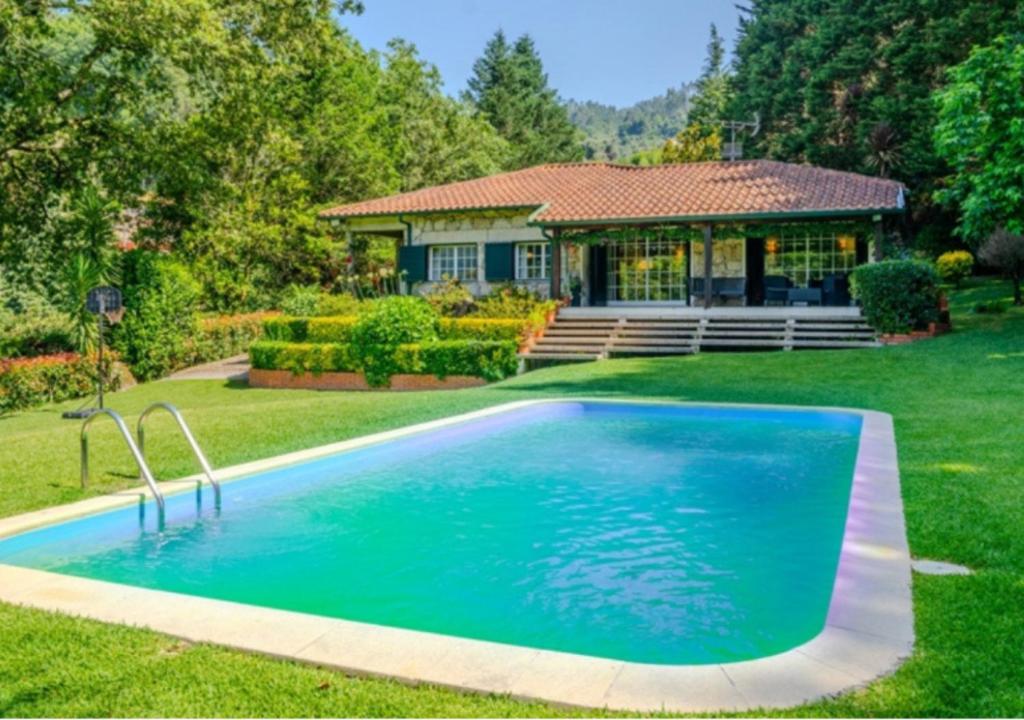 a swimming pool in the yard of a house at Green Villa Gerês in Geres