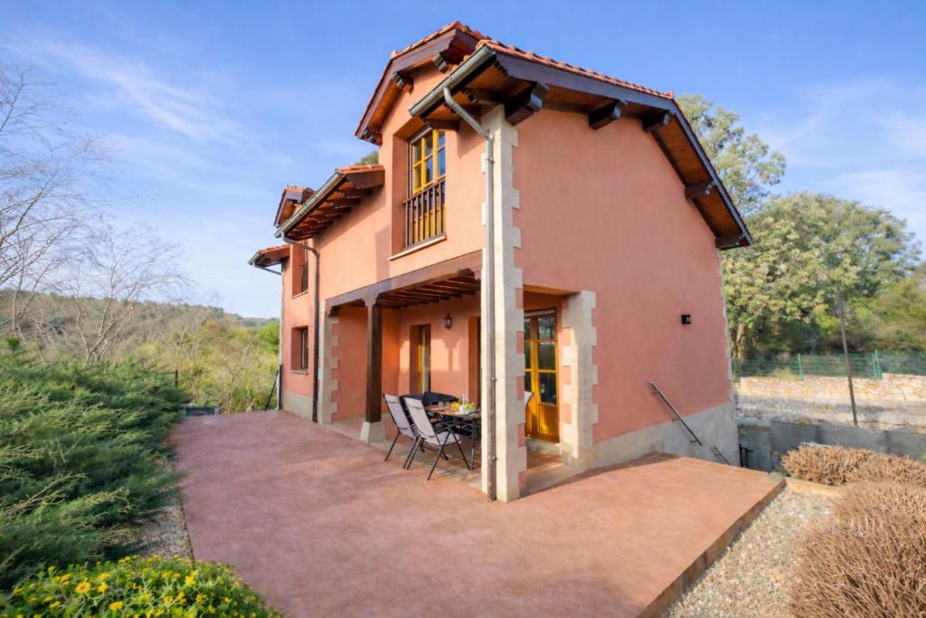 a house with two chairs on a patio at Playa de La Franca, jardín y WiFi - Casa Freya in La Franca