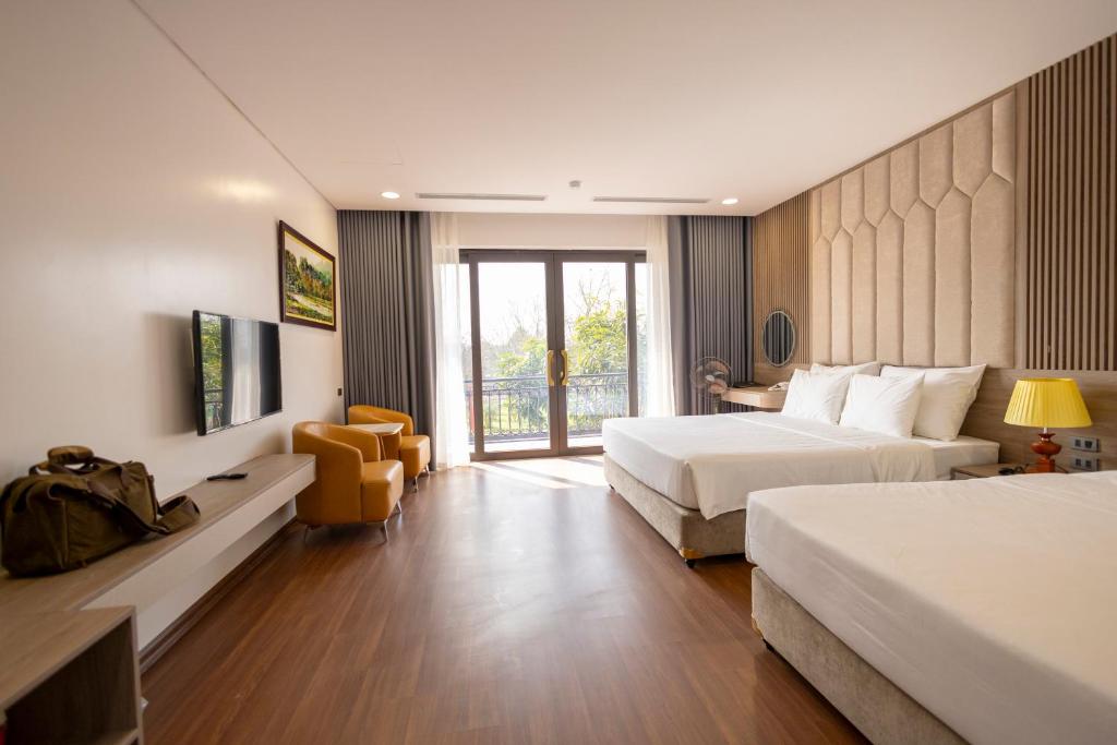 a hotel room with two beds and a window at Mai Lakeside Hotel Ninh Binh in Kỳ Vĩ