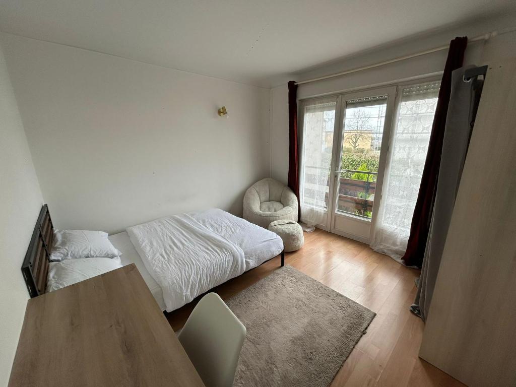 a bedroom with a bed and a chair and a window at Made 1 in Le Mans