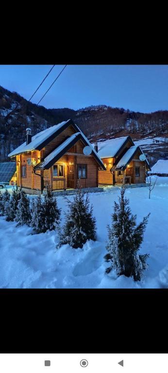 a log cabin in the snow with christmas trees at Riverland Cottage 2 in Kolašin