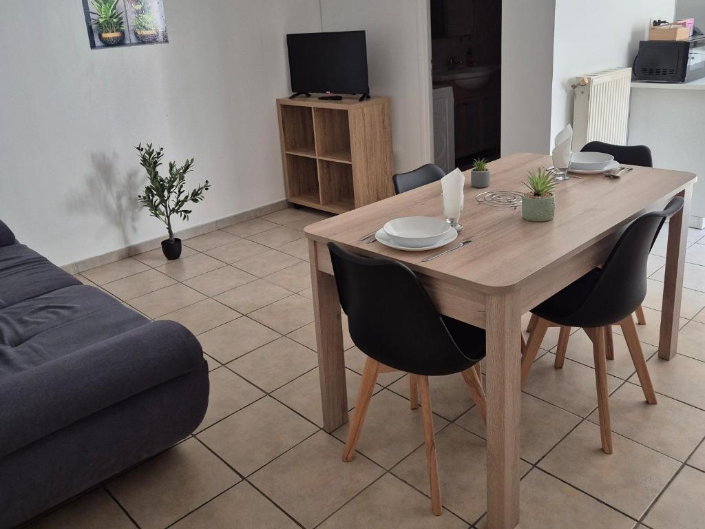 a living room with a wooden table and chairs at Le lumineux-T2 calme-animaux acceptés-place auto in Saint-Gaudens