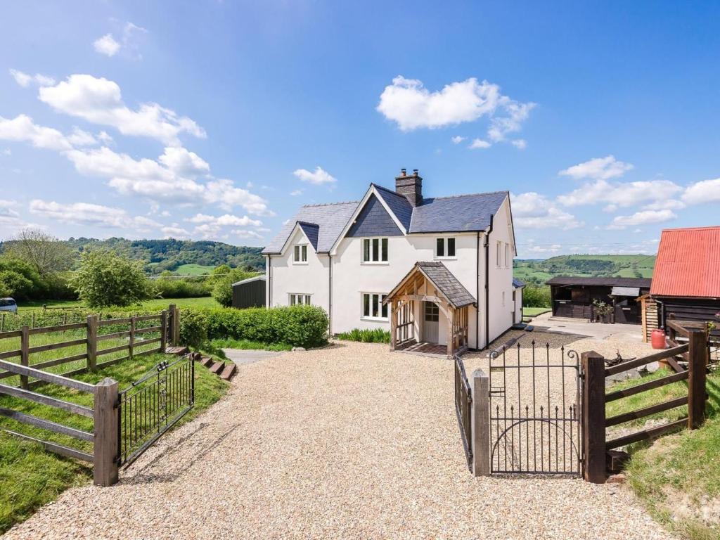 a white house with a gate and a fence at 4 Bed in Llandinam oc-51651 in Llandinam