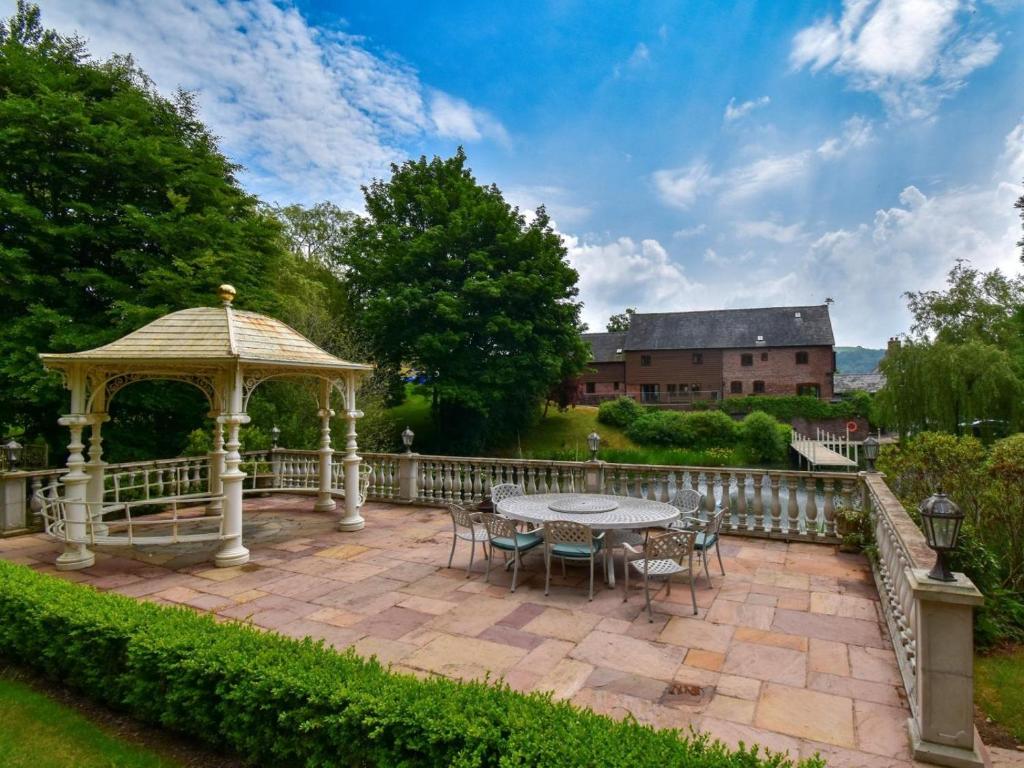 a gazebo with a table and chairs on a patio at 4 Bed in Newtown oc-86784 in Bettws Cedewain