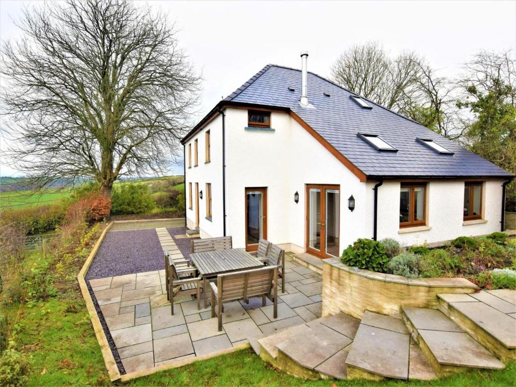 a white house with a patio and a table and chairs at 4 Bed in Llandysul oc-66640 in Llandysul
