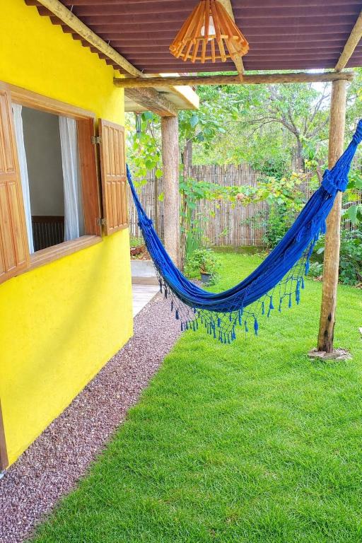 a blue hammock hanging from the side of a house at Pousada Raízes do Cipó in Serra do Cipo
