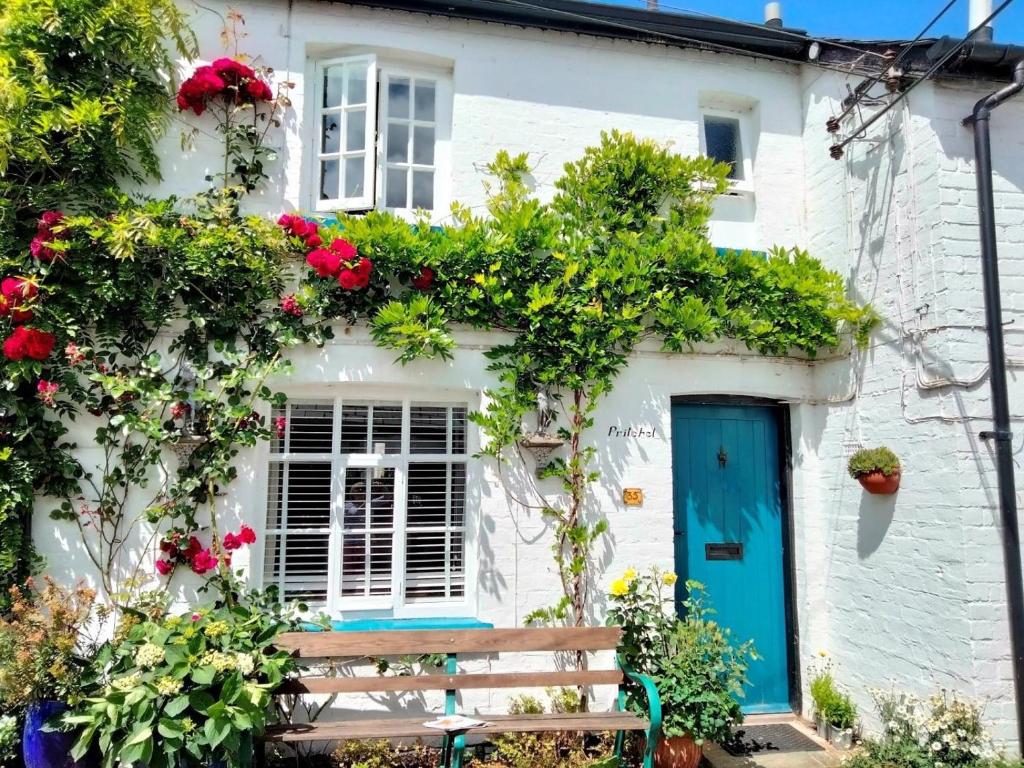 a white house with a blue door and flowers at 1 Bed in Presteigne oc-55285 in Presteigne