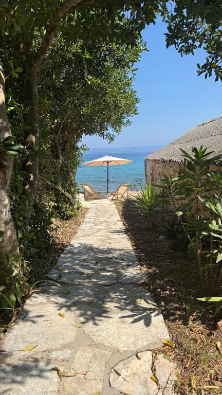 a path with an umbrella next to the ocean at Villa Biankura in Blato