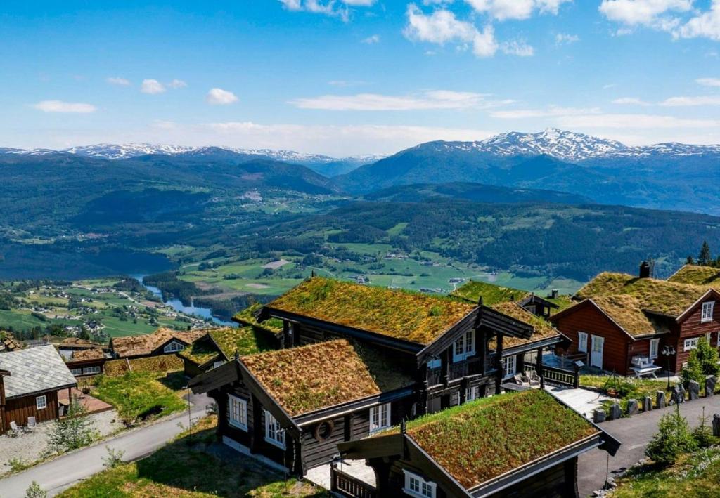 a view of a village with mountains in the background at Log Cabin With Panoramic Views At Voss Resort in Skulestadmo