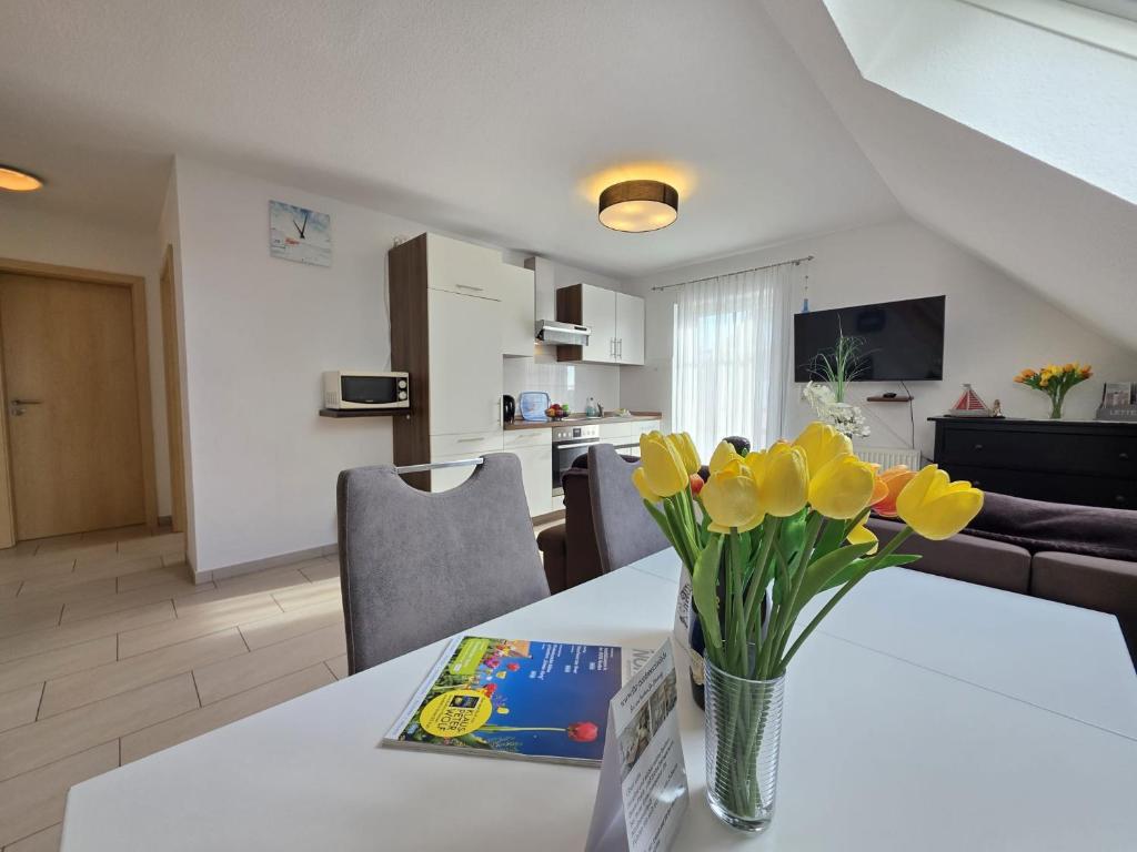 a vase of flowers on a table in a living room at Ferienwohnung Südwind Norddeich in Norden