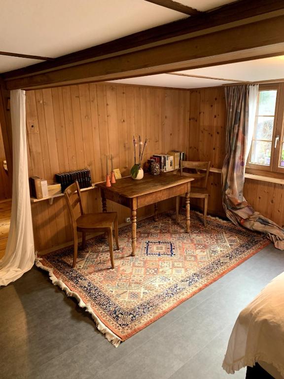 a room with a desk and a table with chairs at Swiss Mountain Chalet in Saxeten