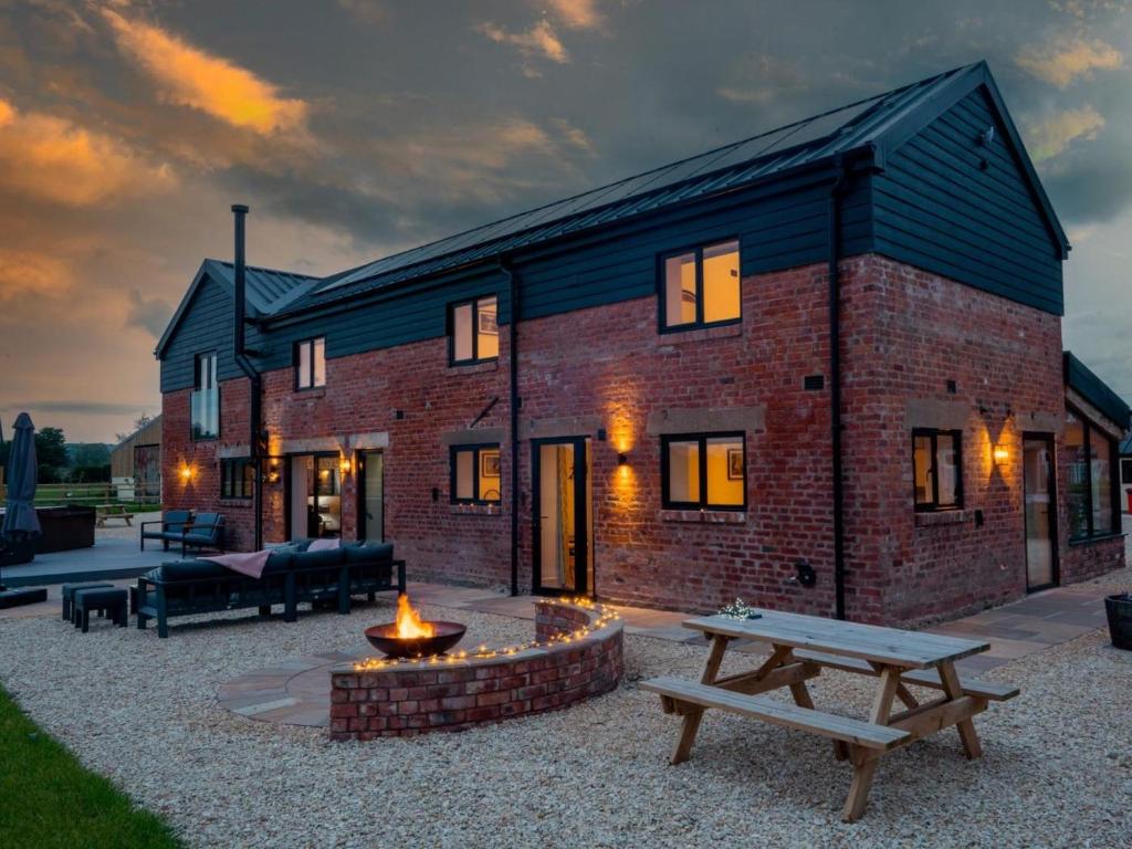 a brick house with a fire pit in front of it at 14 Bed in Welshpool oc-90568 in Berriew
