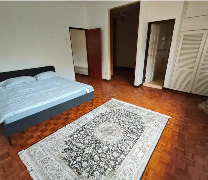 a bedroom with a bed and a rug on a wooden floor at Readers heaven in Ampang
