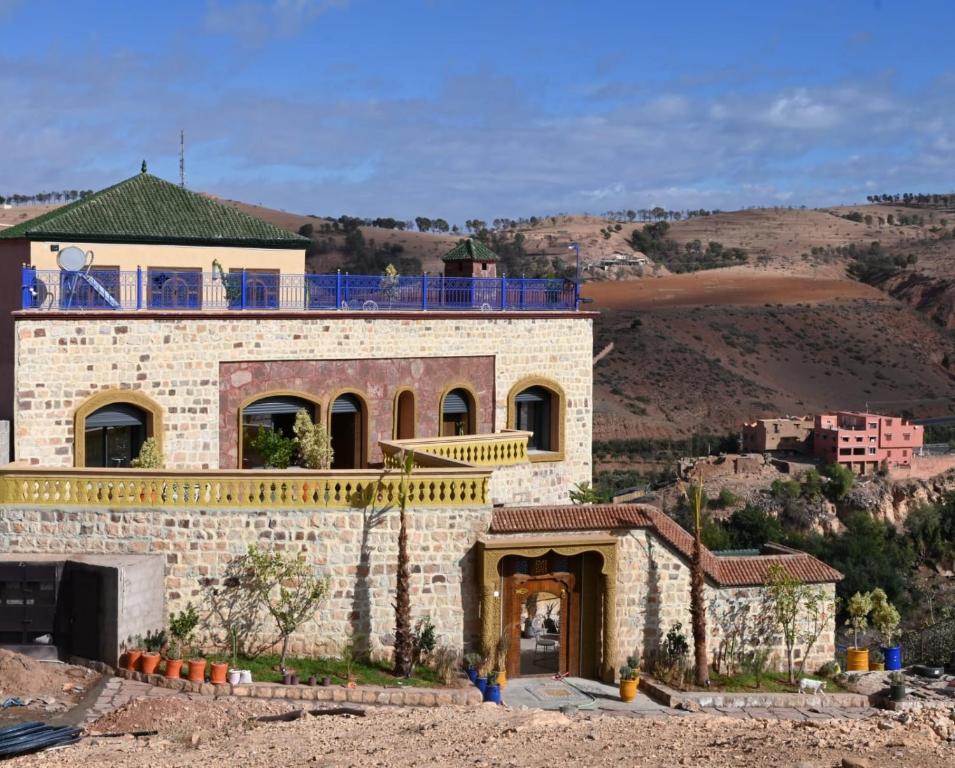 a large brick house with a balcony on top of it at Bihi Lodge in Tahannout