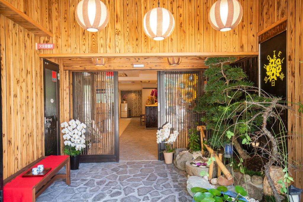 a lobby with wooden walls and a red bench and plants at Hotel 向日葵 in Osaka