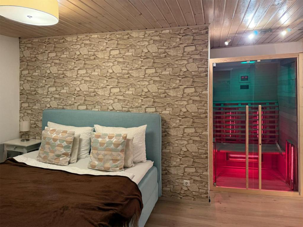 a bedroom with a bed with a stone wall at Bergromantik Ferienwohnung Charme mit einer Infrarotkabine und Bergblick in Marktschellenberg