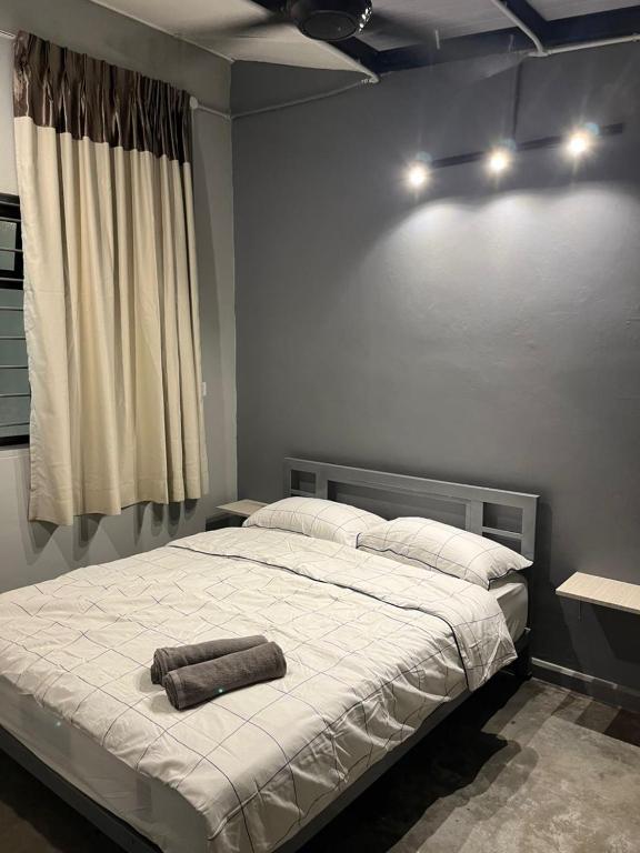 a bedroom with a large bed with two towels on it at Roomah En-suite attached-bath R6 in Ipoh