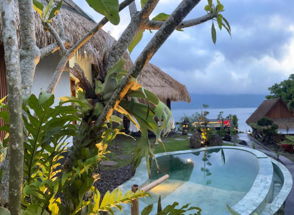 a resort pool with a view of the ocean at Santhi Loka in Kubupenlokan