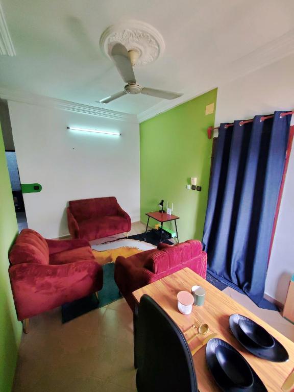 a living room with red furniture and a table at Green Appart 1 chambre et salon in Cotonou