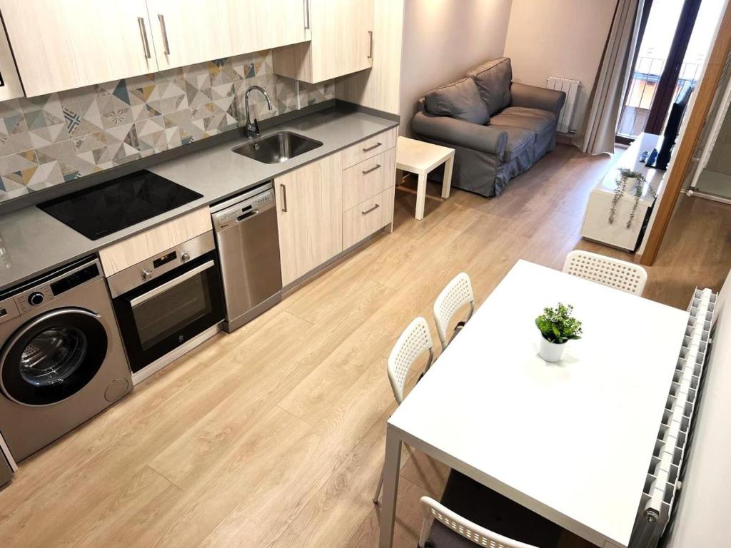 a kitchen and living room with a table and a sink at Apartamento centro de Puigcerda in Puigcerdà