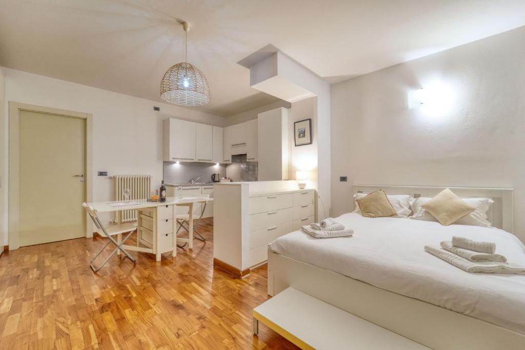 a bedroom with a bed and a desk and a kitchen at Sergio's house in Como