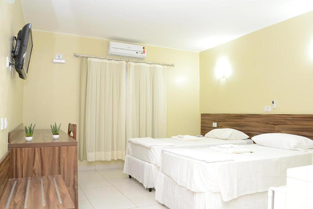 a hotel room with two beds and a television at Requinte Hotel in Altamira