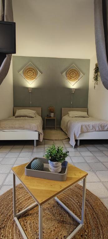 a living room with two beds and a table at studio meublé classé 2 étoiles - 30m² in Gréoux-les-Bains