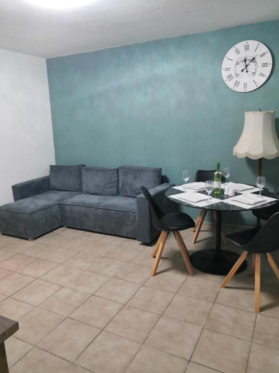 a living room with a couch and a table with a clock at Schöne Wohnung Prima am Bahnhof Schwerte in Schwerte
