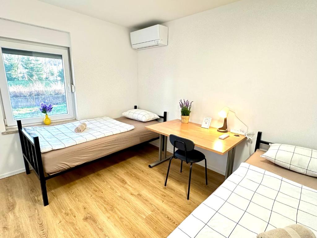 a bedroom with a bed and a desk and a window at Rookos rooms in Ljubljana