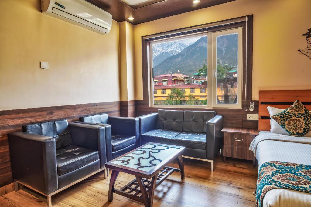 a hotel room with a couch and a window at Hotel Buddha House Himalayan Brothers in Dharamshala