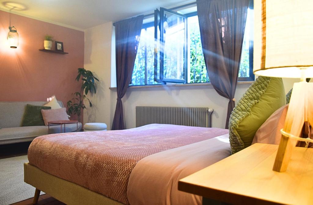 a bedroom with a bed and a couch and a window at Ponte House in Piaia
