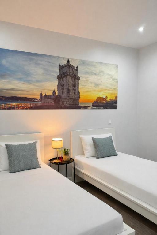 two beds in a room with a painting on the wall at Velvet Prime Stay in Lisbon