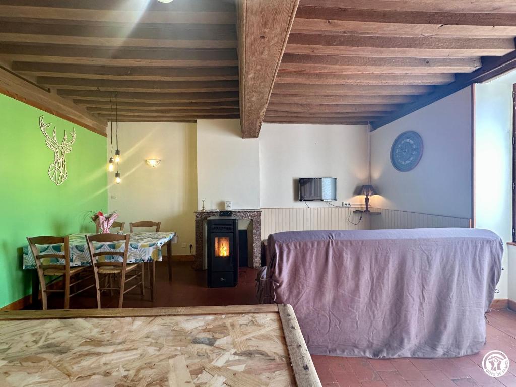 a living room with a table and a dining room at Le Refuge in Liernais