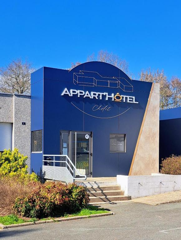 a building with a sign on the side of it at Appart hotel Cholet Carteron in Cholet