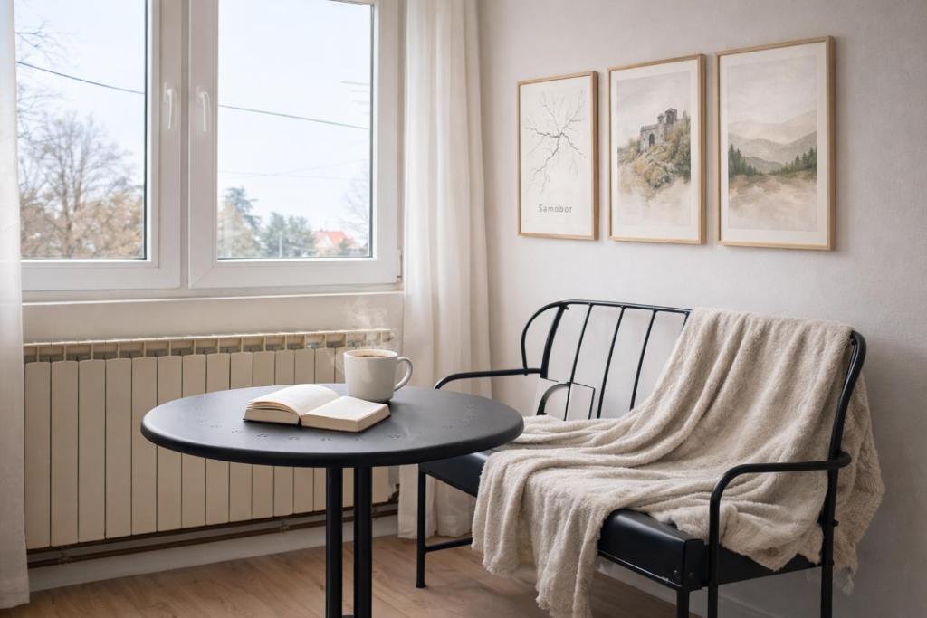 a room with a table and a chair with a book at Quiet & Cozy Apartment near Samobor - Terrace, Parking, Close to Zagreb & Tabor in Samobor