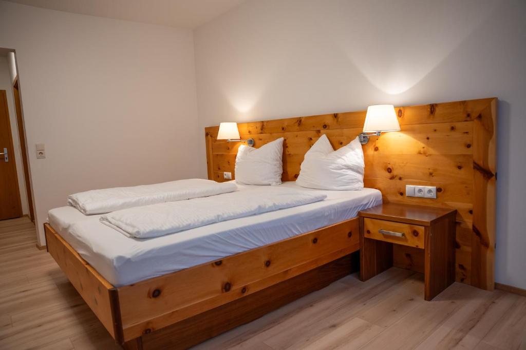 a bedroom with a wooden bed with two pillows at Braugast Kreuz in Frastanz
