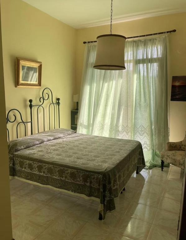 a bedroom with a bed and a large window at Lo studio di Gabriella in Bolsena