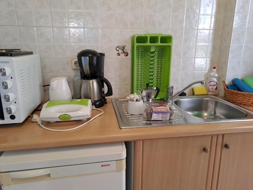 a kitchen counter with a sink and a microwave at Ground floor economy studio in karmiris studios in Zakynthos