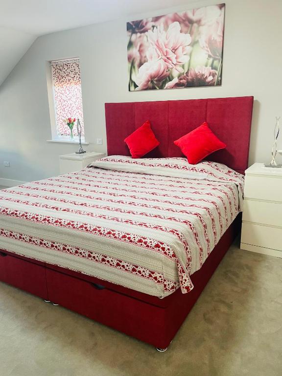a red bed with red pillows in a bedroom at Cozy Private Room & Breakfast Dublin 15 in Tyrrelstown