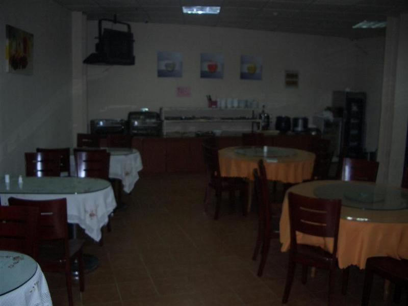 a dining room with tables and chairs with white table cloth at GreenTree Inn Ji‘nan Shanda Road Business Hotel in Jinan