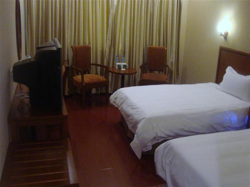 a hotel room with two beds and a flat screen tv at GreenTree Inn Ji‘nan Shanda Road Business Hotel in Jinan