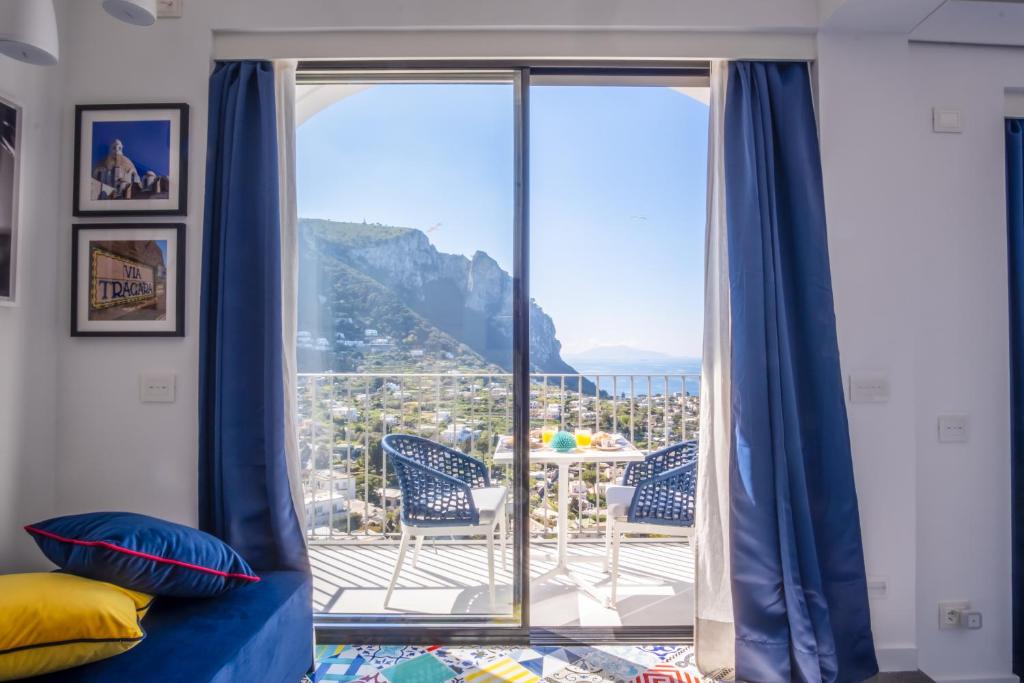 ein Zimmer mit einem großen Fenster und Blick auf den Berg in der Unterkunft Domus Capri in Capri