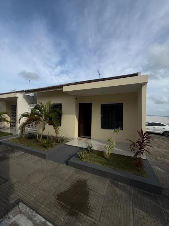 a house with a car parked in front of it at Casa de praia PB in Pitimbu
