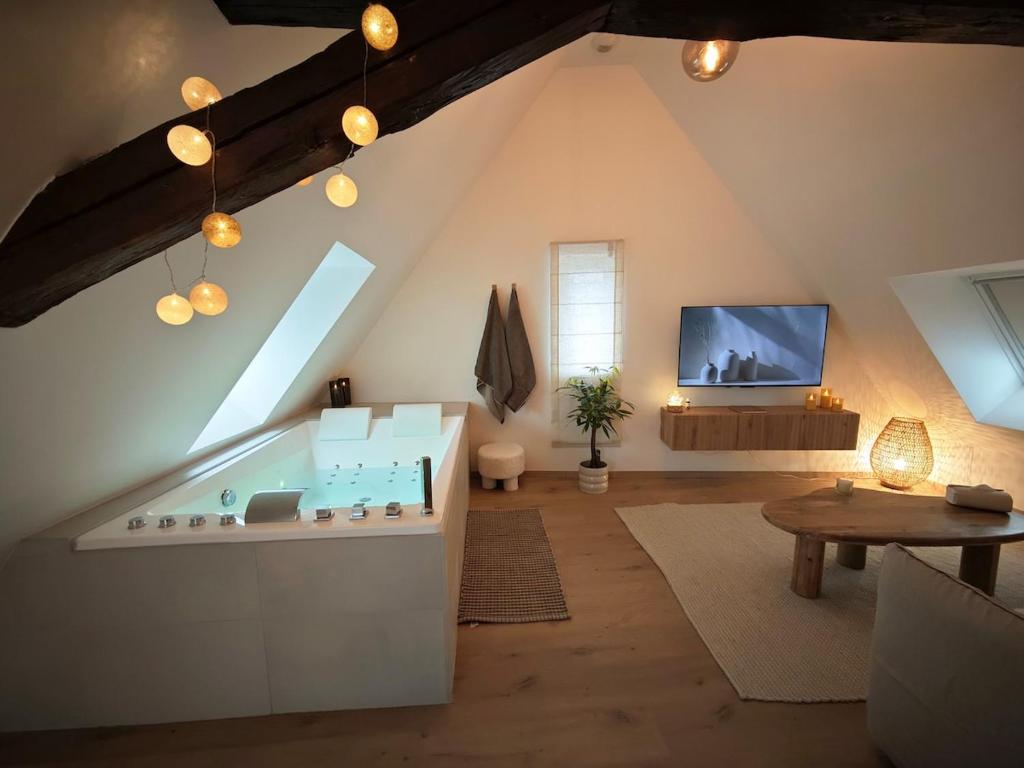 a attic bathroom with a tub in a room at Slow Suite & Spa Erstein in Erstein