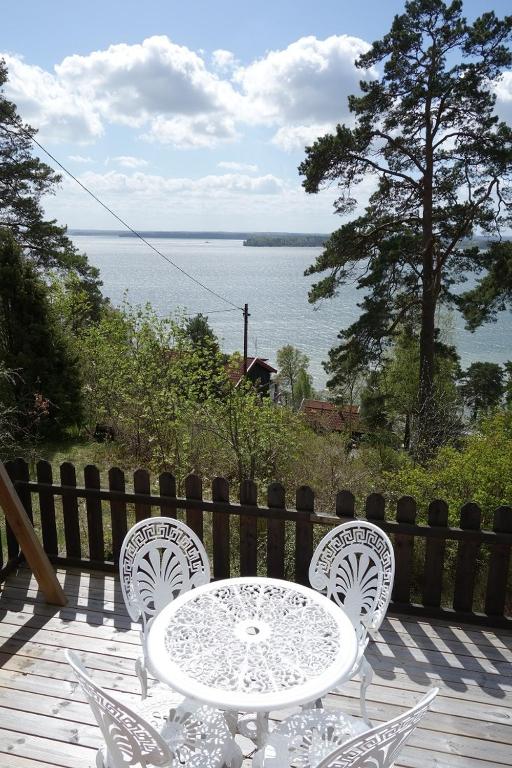 a table and chairs on a deck with a view of the water at Cabin with beautiful view in Kolmården